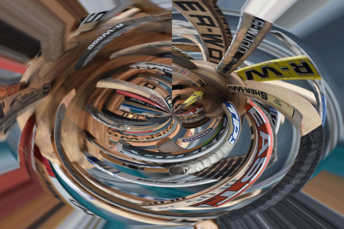 a bunch of old hockey sticks sticking out of wooden ball, but the image is swirled around to distort the size and make them blurry