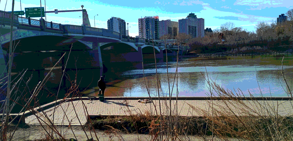 A posterized image of a lone individual standing on a concrete dock with a fishing rod next to a large bridge with an overhanging green sign saying 'rue Main St' and tall buildings in the background