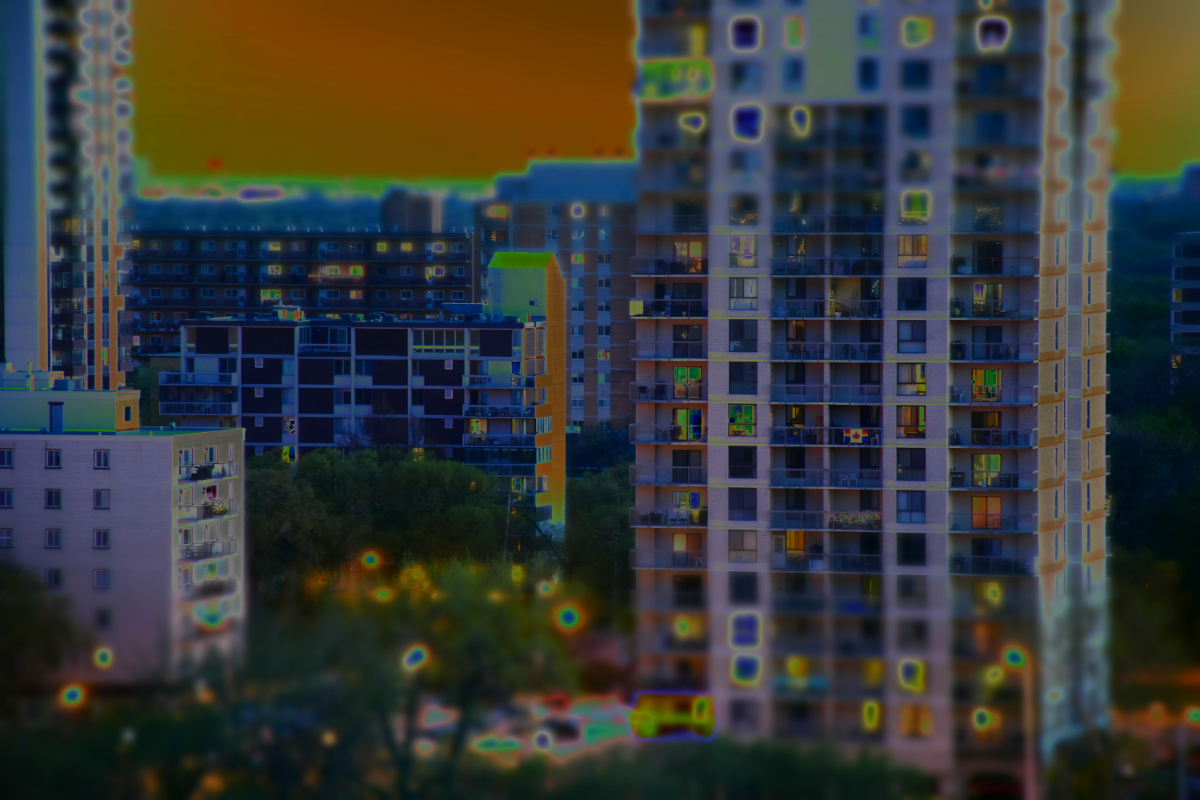 a tilt shift image of several apartment buildings close up, with the top and bottom thirds blurry and the middle third in focus, but solarized to make everything glow in reversed colours.