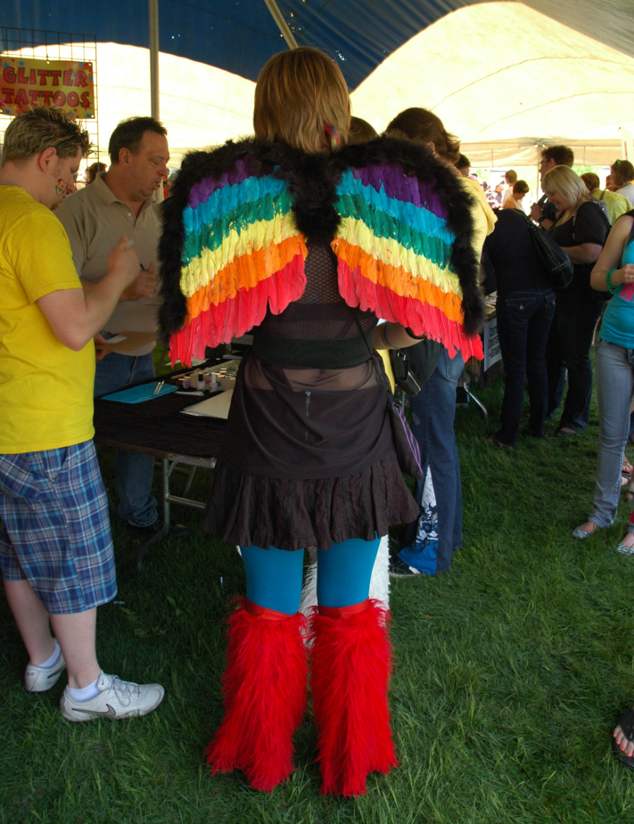 Winnipeg Pride, 2011 The back of a person wearing a costume with rainbow angel wings and red feathery fuck-me boots