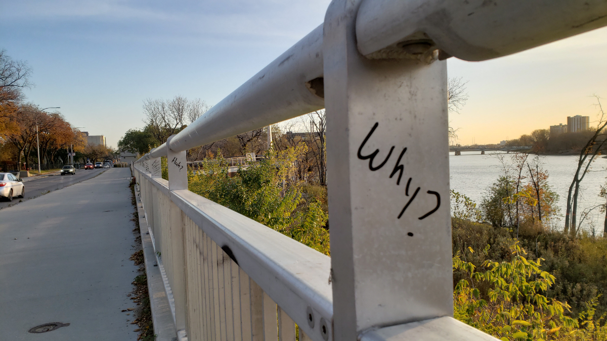 a railing along a sidewalk with with metal posts where words have been scribbled on in permanent marker saying 'Why?' on the first, 'Huh?' on the second, and illegible ones on each into the distance.