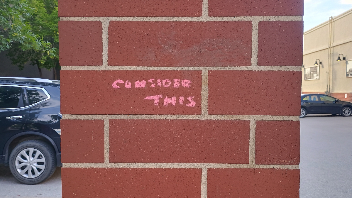 Winnipeg a brick column with 'consider this' written in pink chalk