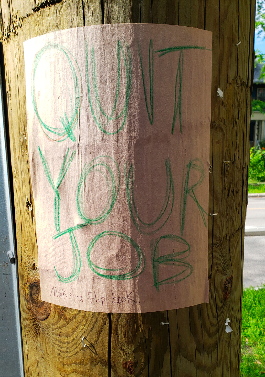 A wooden telephone pole with a QUIT YOUR JOB poster on light pink paper with green writing and the bottom message 'Make a flipbook'