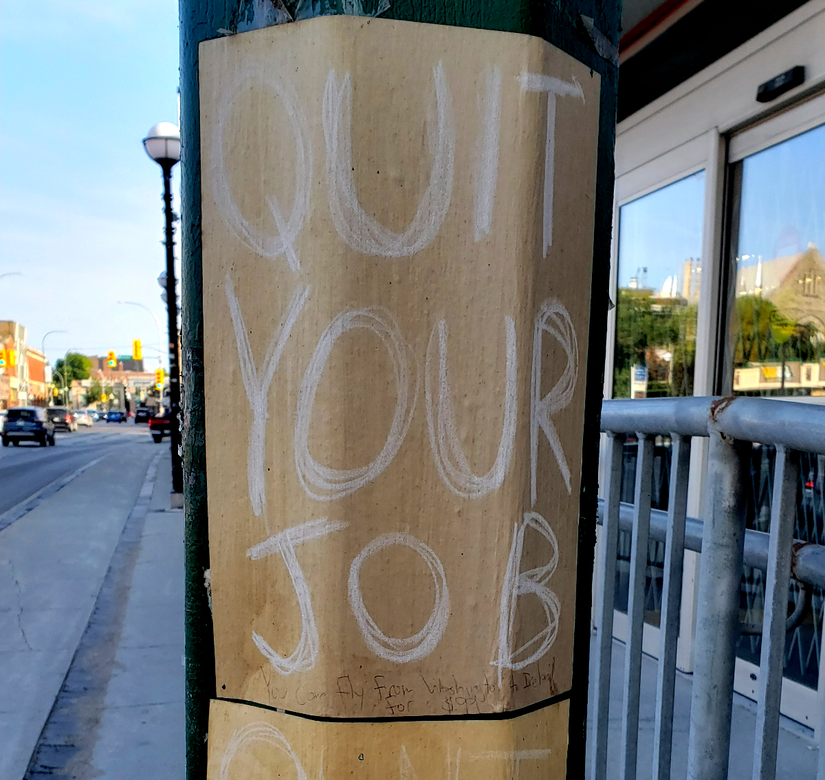 QUIT YOUR JOB sign on a lamppost with 'You can fly from Washington to Ireland for $99' in pen