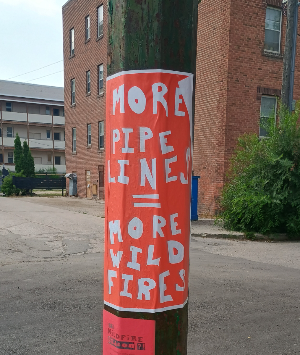 a red poster with white cutout letters saying 'more pipelines = more wildfires'