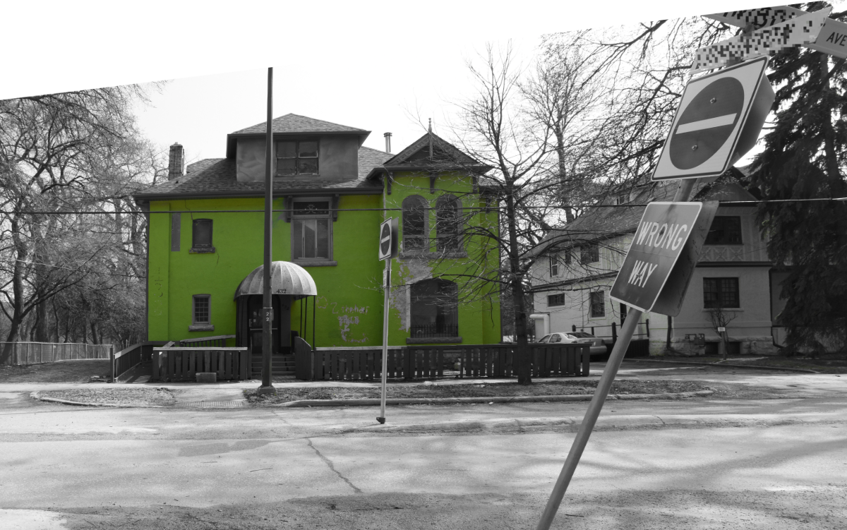 a lop-sided selective colour image with everything black and white except for a very bright lime green house in the background. In the foreground is a WRONG WAY sign on a slanted pole that looks like it's been bent out of shape by being hit with a car.