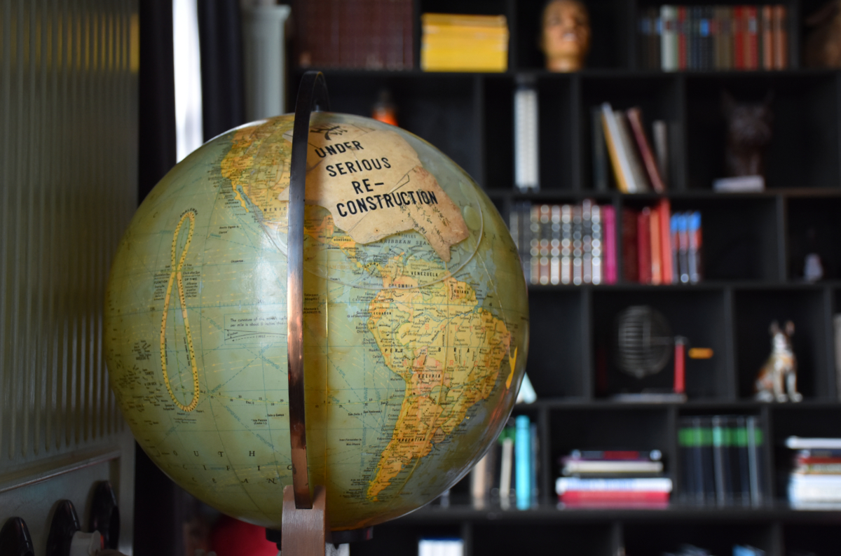 a globe with a sticker over North America that says 'UNDER SERIOUS RECONSTRUCTION'